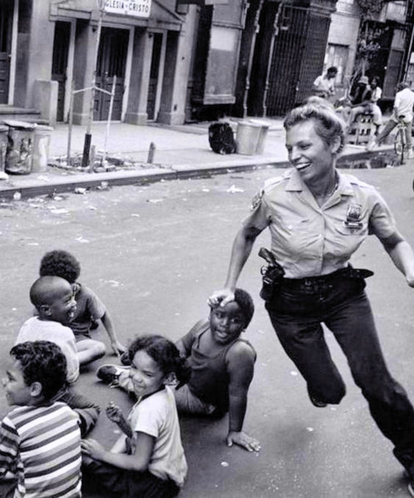 A New York police officer playing with children in the street in 1970. 